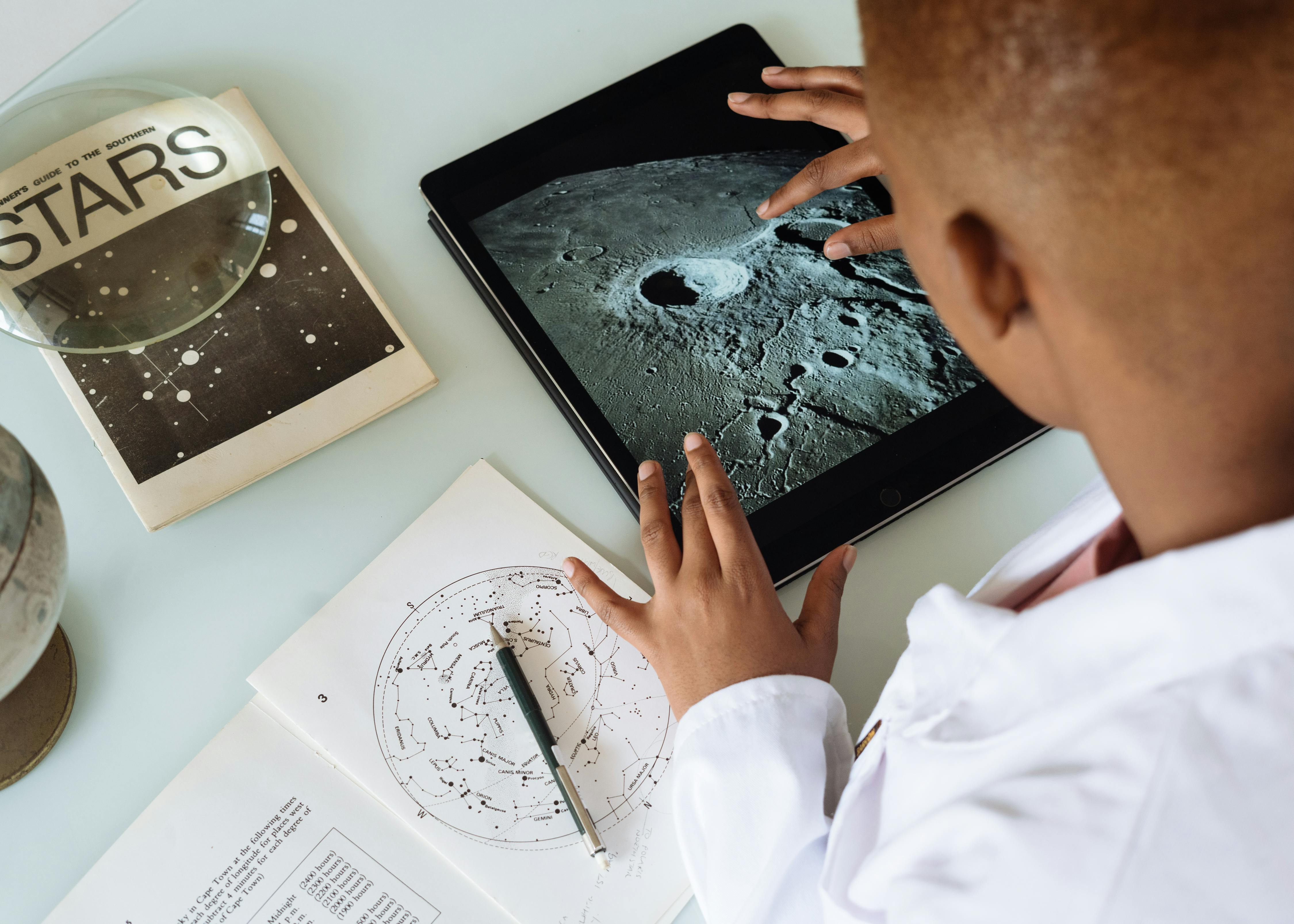 crop afrіcan american student studyіng craters of moon on tablet at oЬservatоry