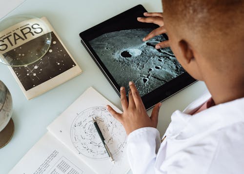 在天文台播種學習平板電腦上的月亮隕石坑的非洲裔美國學生