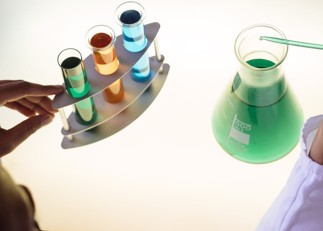 laboratory technician examining interaction of different colored chemicals
