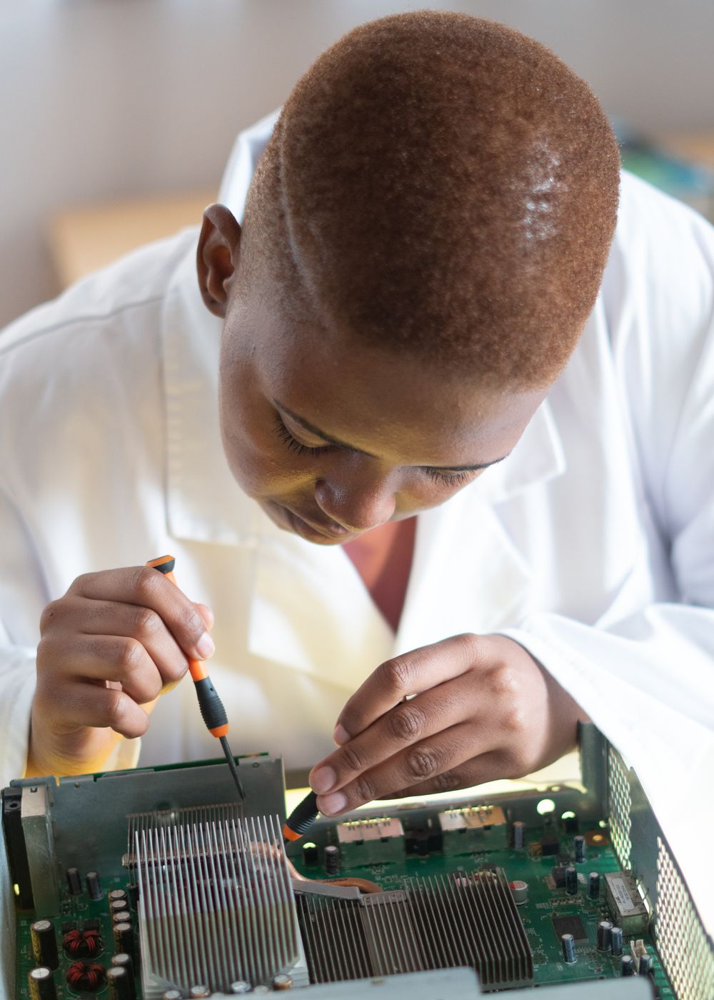Technician repairing a laptop motherboard in a workshop