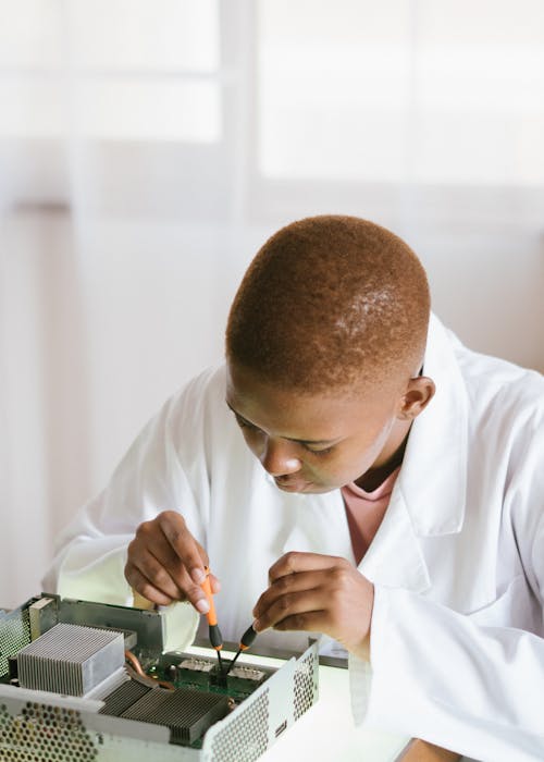 Focused African American technical worker replacing faulty elements on video card