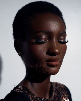 Striking portrait of a woman with closed eyes and bold, artistic makeup in Lagos, Nigeria.