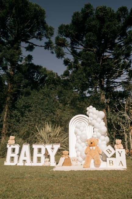 Fotomural Montaje de baby shower inspirado en la naturaleza con ositos de peluche y globos entre la vegetación.