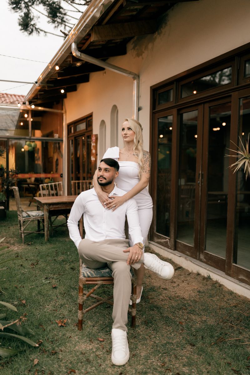 Elegant couple posing outside cozy home
