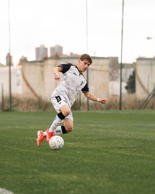 Free A soccer player skillfully dribbles the ball on an outdoor field during the day. Stock Photo