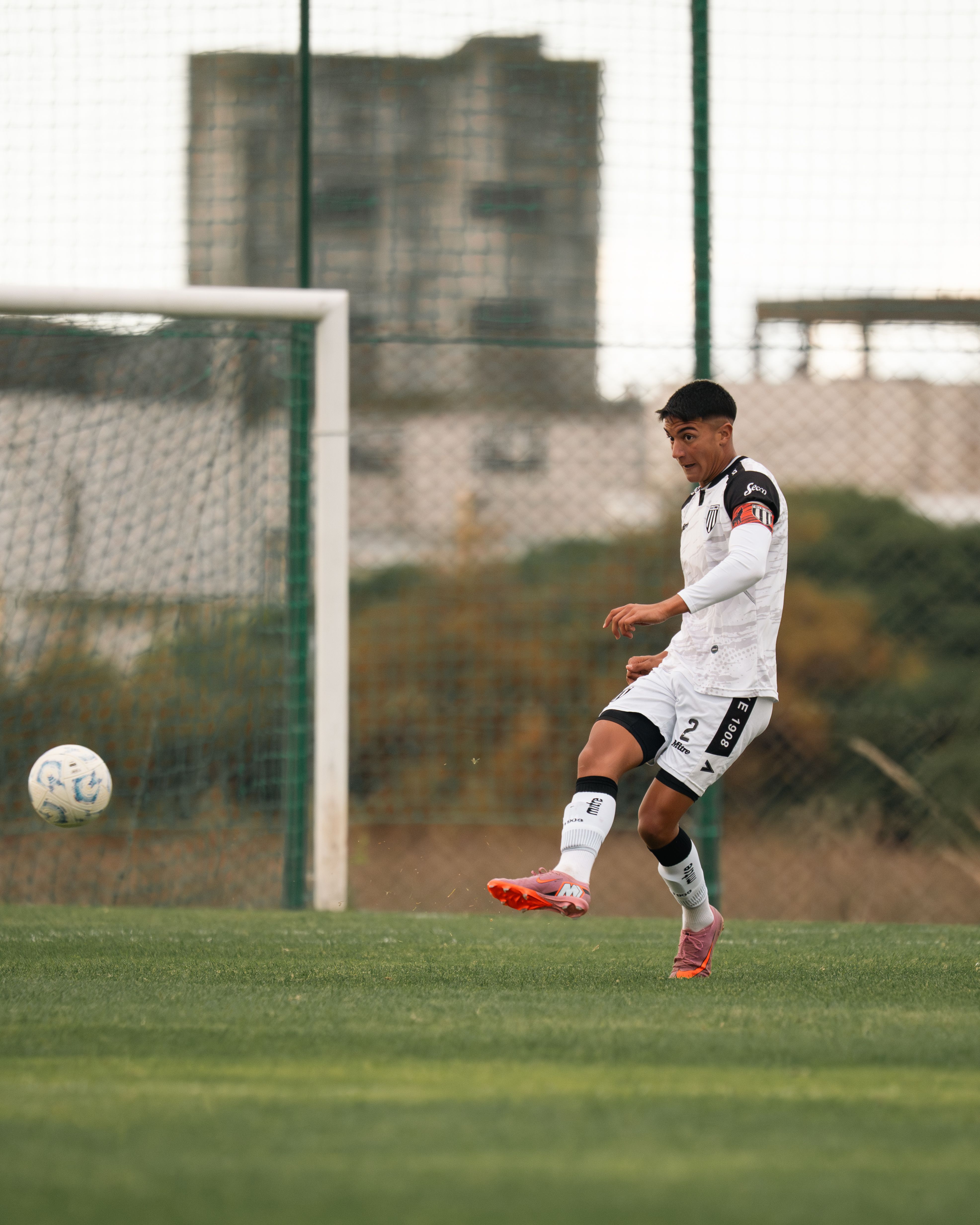 Athletic soccer player in motion with focused expression during outdoor match.