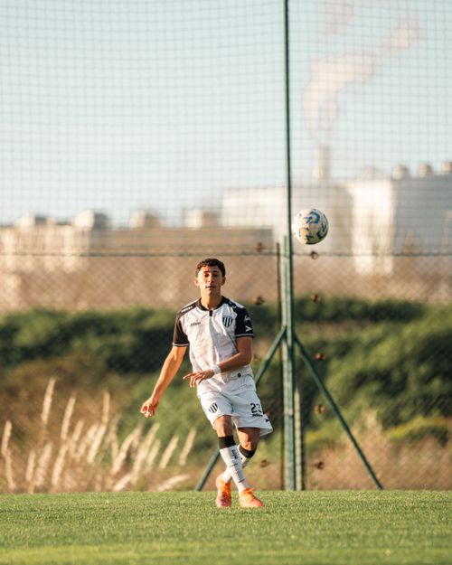 Free Teen soccer player in action on the field, demonstrating concentration and agility during a match. Stock Photo