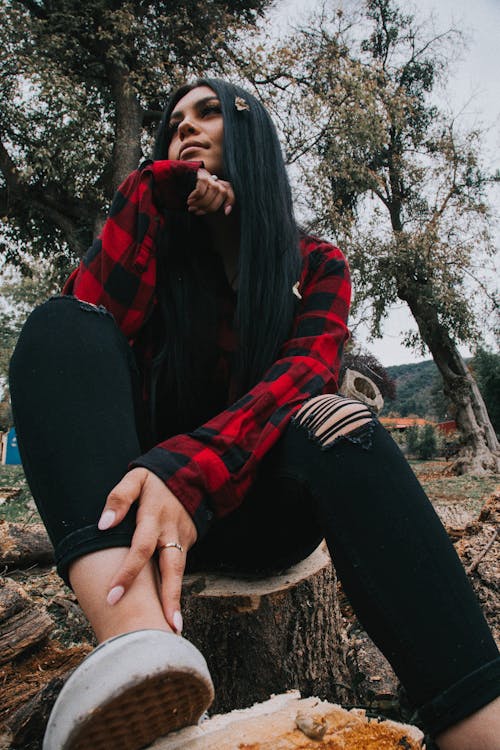 Alicia reacción Opresor Mujer En Camisa De Manga Larga A Cuadros Rojos Y Negros Y Pantalones Negros  Sentado En Un Tronco De árbol · Foto de stock gratuita