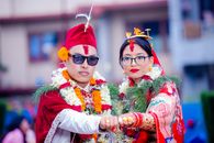 Culturally rich traditional wedding couple adorned in vibrant attire and floral garlands.