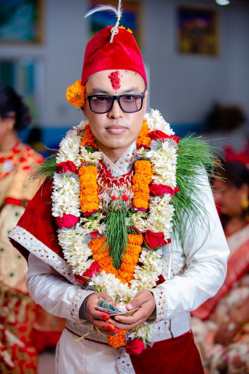 Free Asian groom adorned with vibrant garlands and traditional attire at a cultural wedding ceremony. Stock Photo