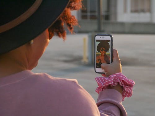 Mujer En Camisa Rosa Y Sombrero Negro Con Smartphone Negro