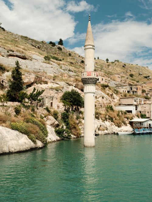Free Scenic view of the submerged minaret in Halfeti, Şanlıurfa, Türkiye, surrounded by water and hillside. Stock Photo
