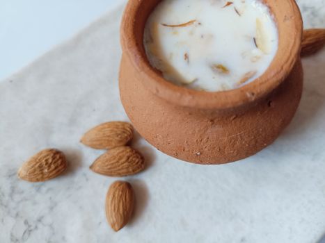 Hyderabadi milk sharbat served in a traditional clay pot with almonds.
