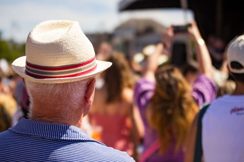 Free A crowd gathers for a lively summer festival in Dublin, Ireland, with a man in a straw hat enjoying the scene. Stock Photo