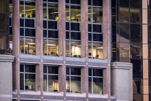 Close-up view of a modern office building exterior, showcasing glass windows and brick architecture during daytime.