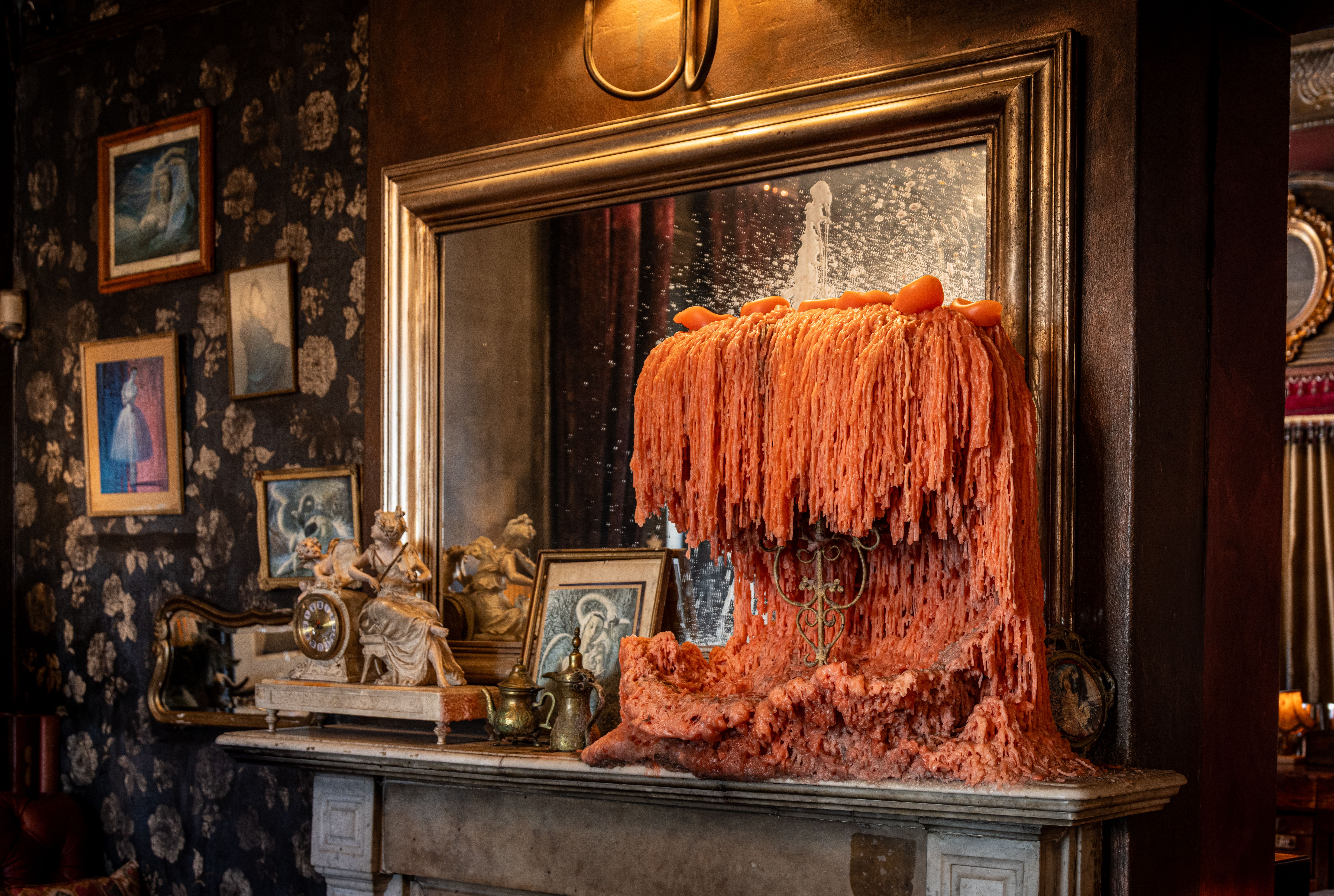 Charming vintage room with tall melting candle and eclectic decor pieces.