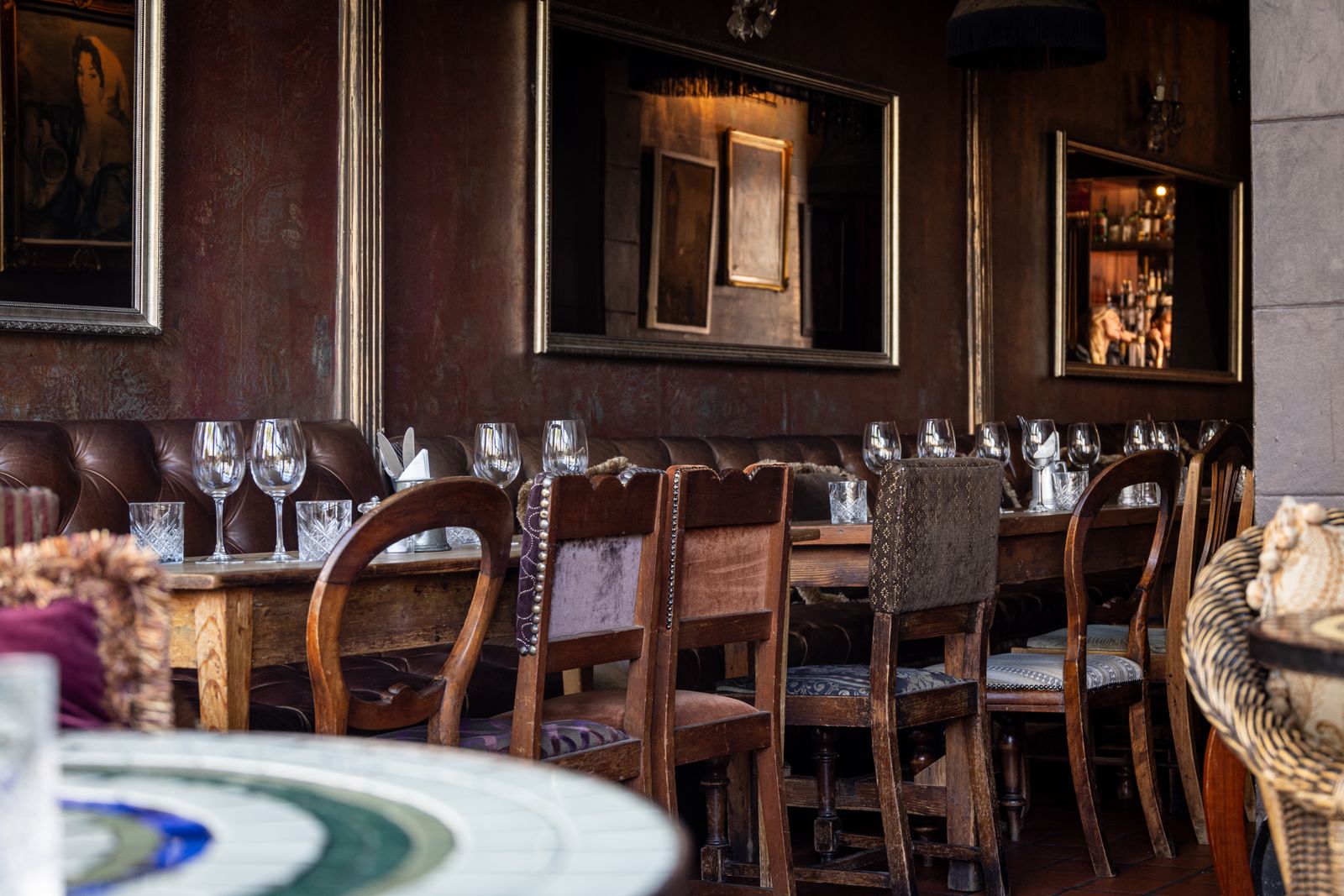 A long table set with crystal glassware in a warm, wood-panelled dining room