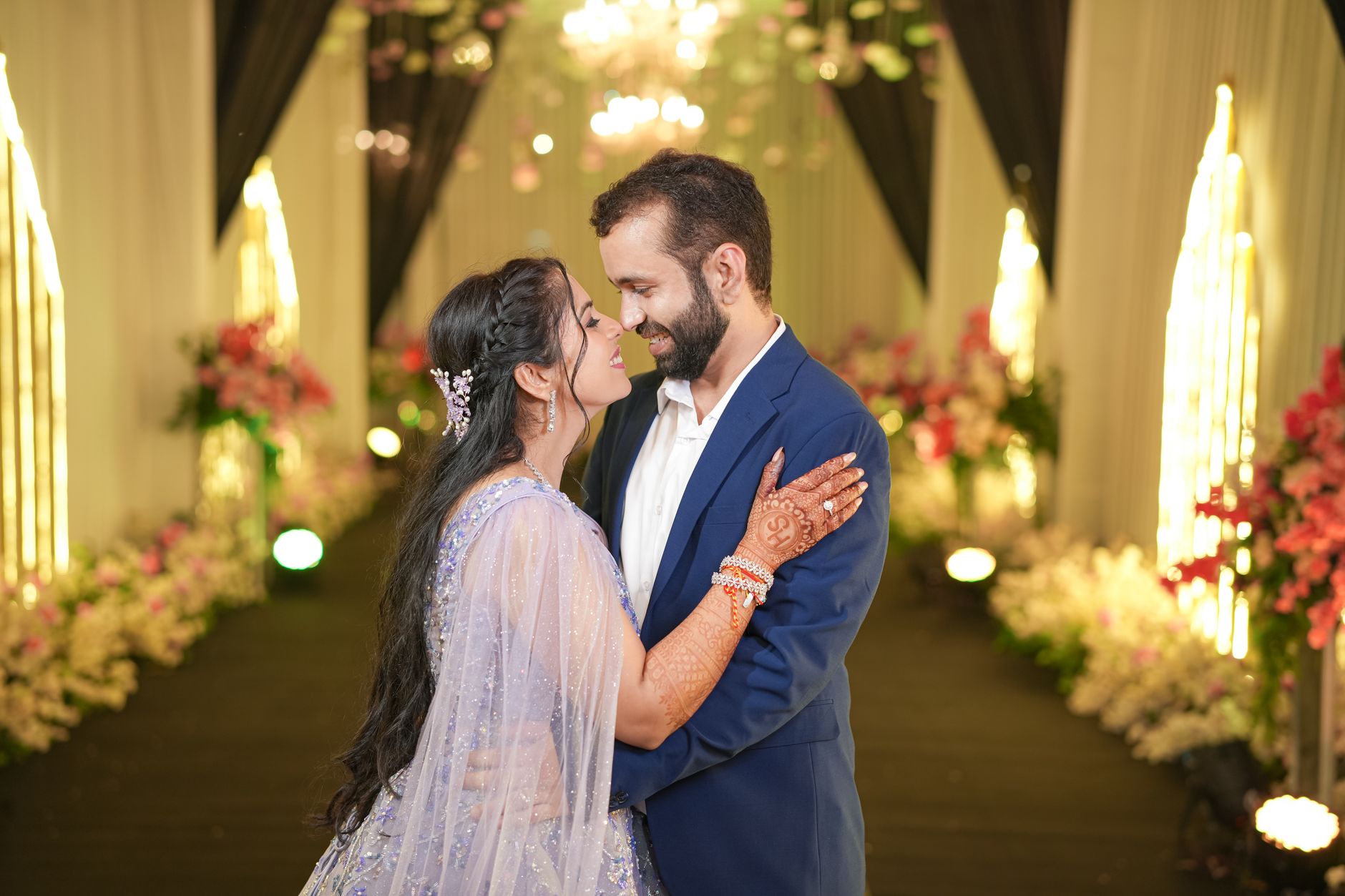 Candid moment of a couple embracing at a luxurious Indian wedding ceremony.