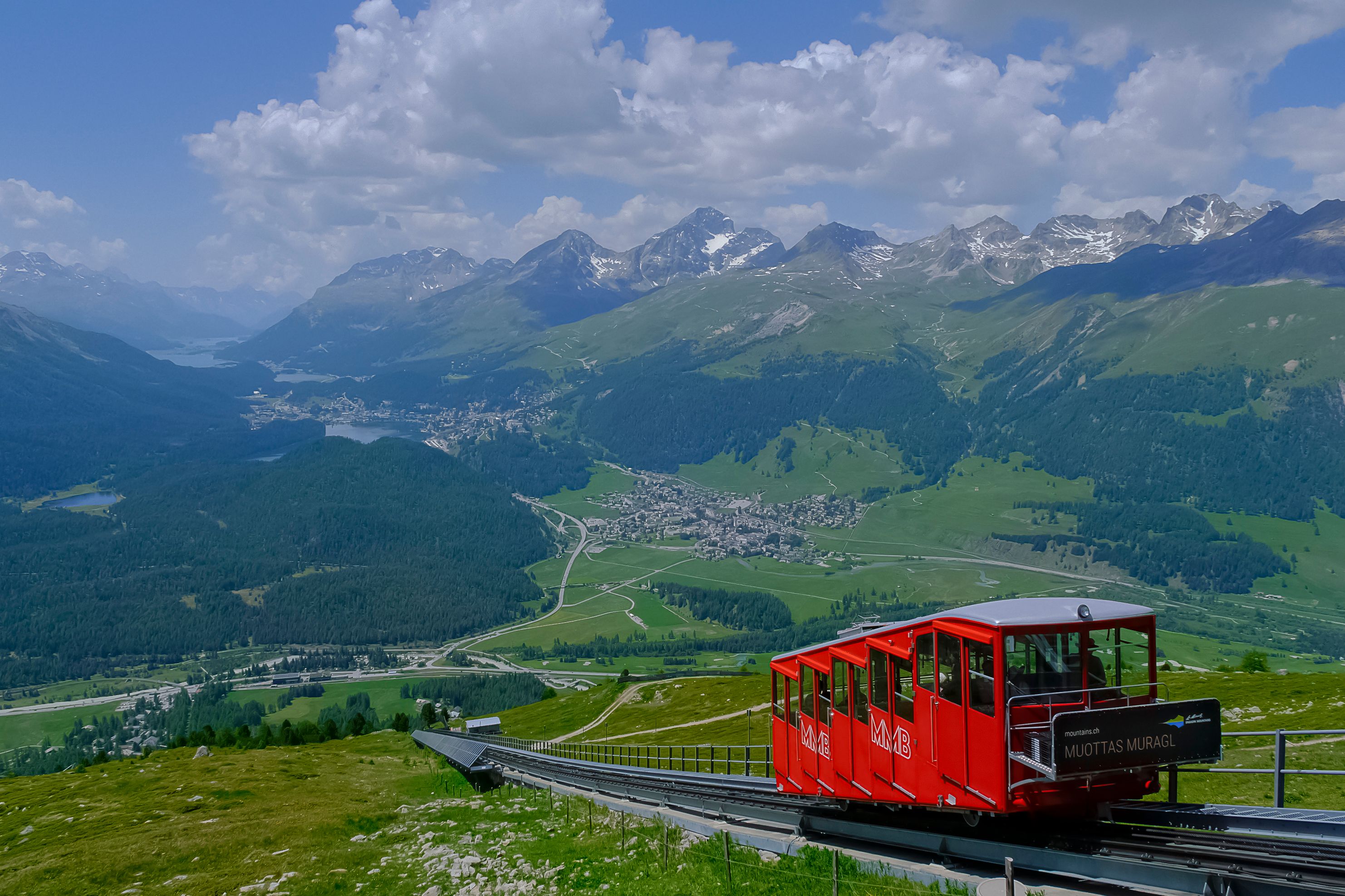 Red funicular climbing Muottas Muragl above the Engadin Valley, a mountain ride where a Swiss pass can cut costs