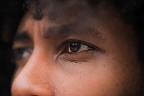 Free Closeup of crop anonymous pensive ethnic person with curly hair looking away thoughtfully Stock Photo