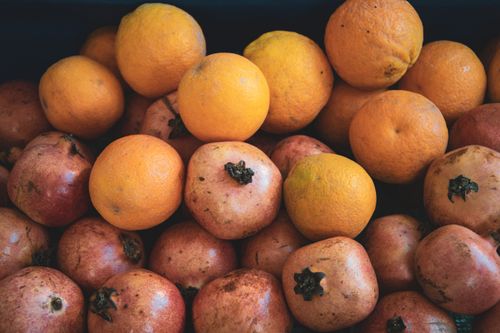 Free Vibrant display of pomegranates and oranges at a local market in Alanya, Türkiye, showcasing seasonal fruits. Stock Photo