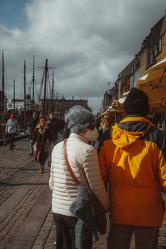 A moody, atmospheric street view in Nyhavn, Copenhagen, showcasing city life and Danish culture.