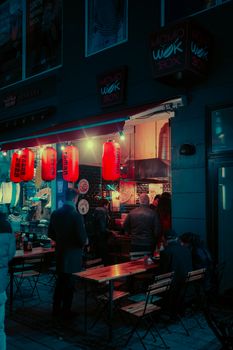 Discover the vibrant Copenhagen street life at night, featuring a bustling noodle bar with iconic red lanterns.