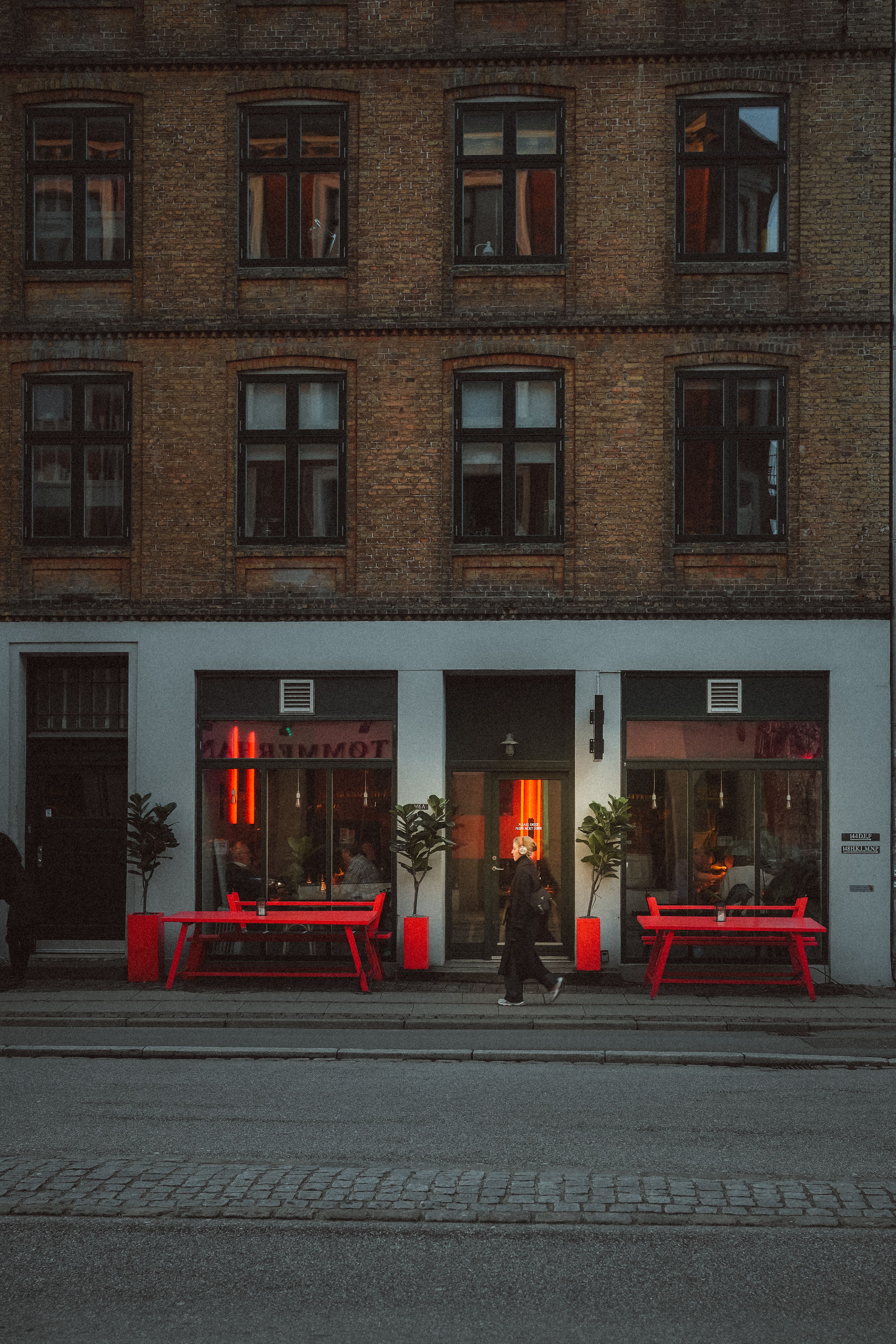 Atmospheric city scene on a Copenhagen street featuring striking red benches.