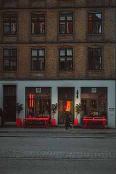 Atmospheric city scene on a Copenhagen street featuring striking red benches.