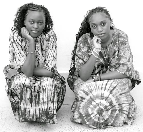 Free Two women pose confidently in matching tie-dye dresses, showcasing style and individuality. Stock Photo
