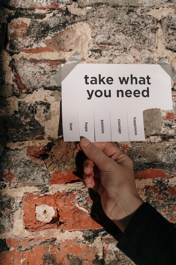 Person Holding A Paper Taped On A Wall