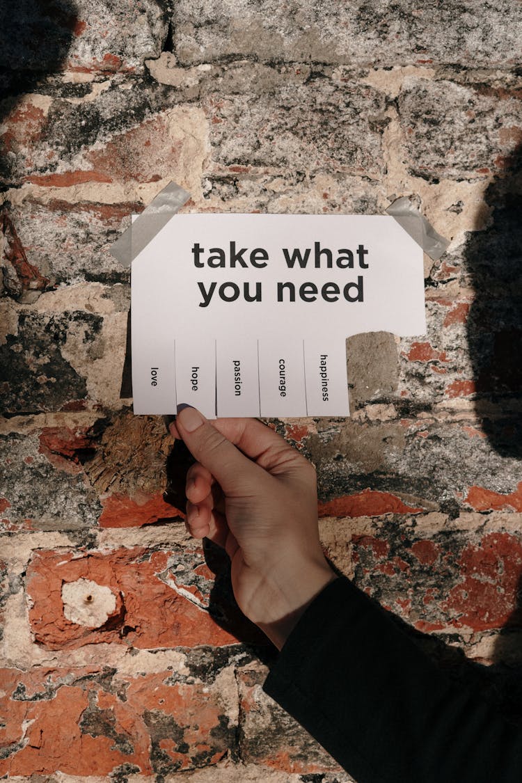 Person Holding A Paper Taped On A Wall