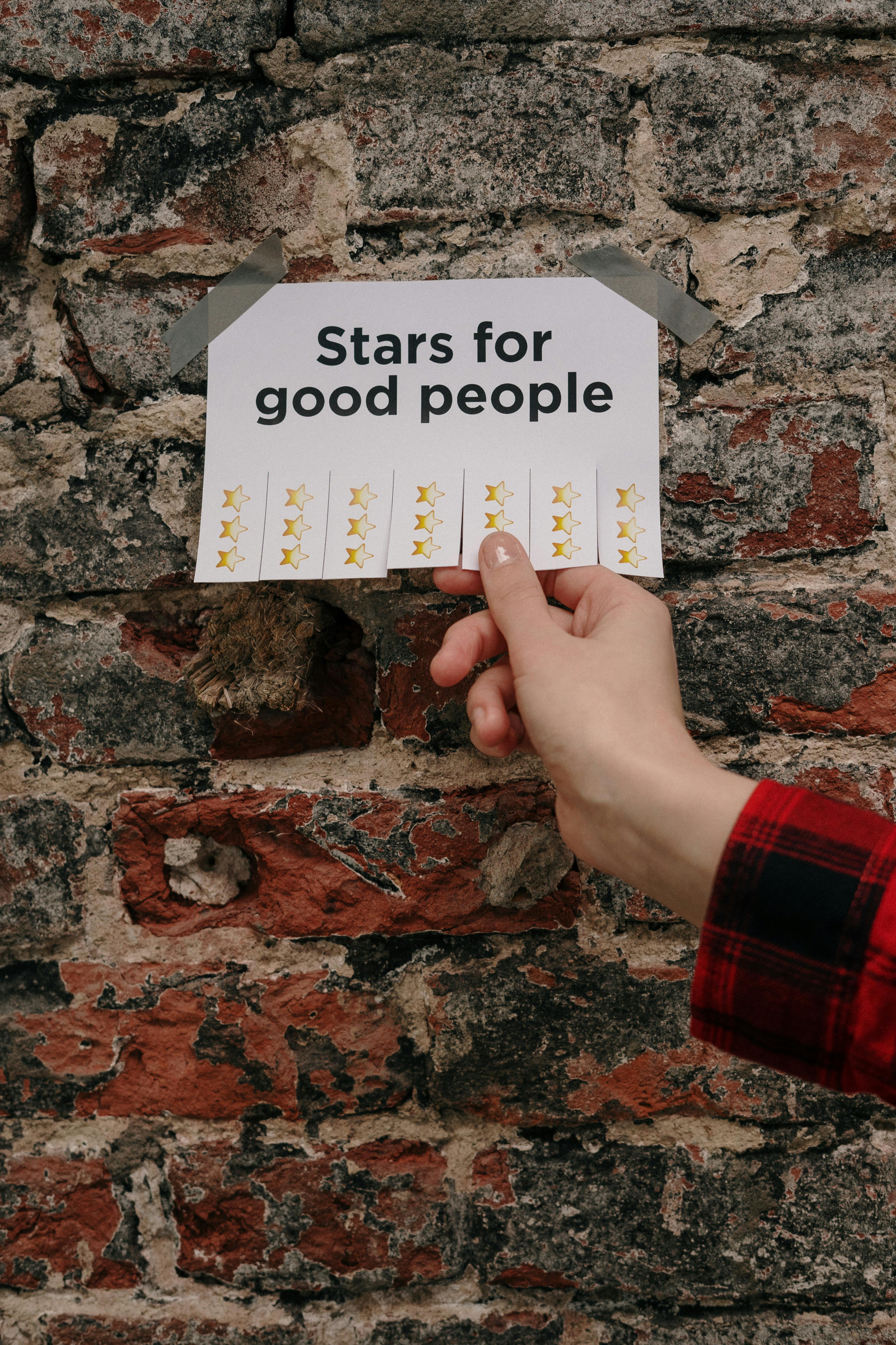 hand holding sheet with writing stars for good people