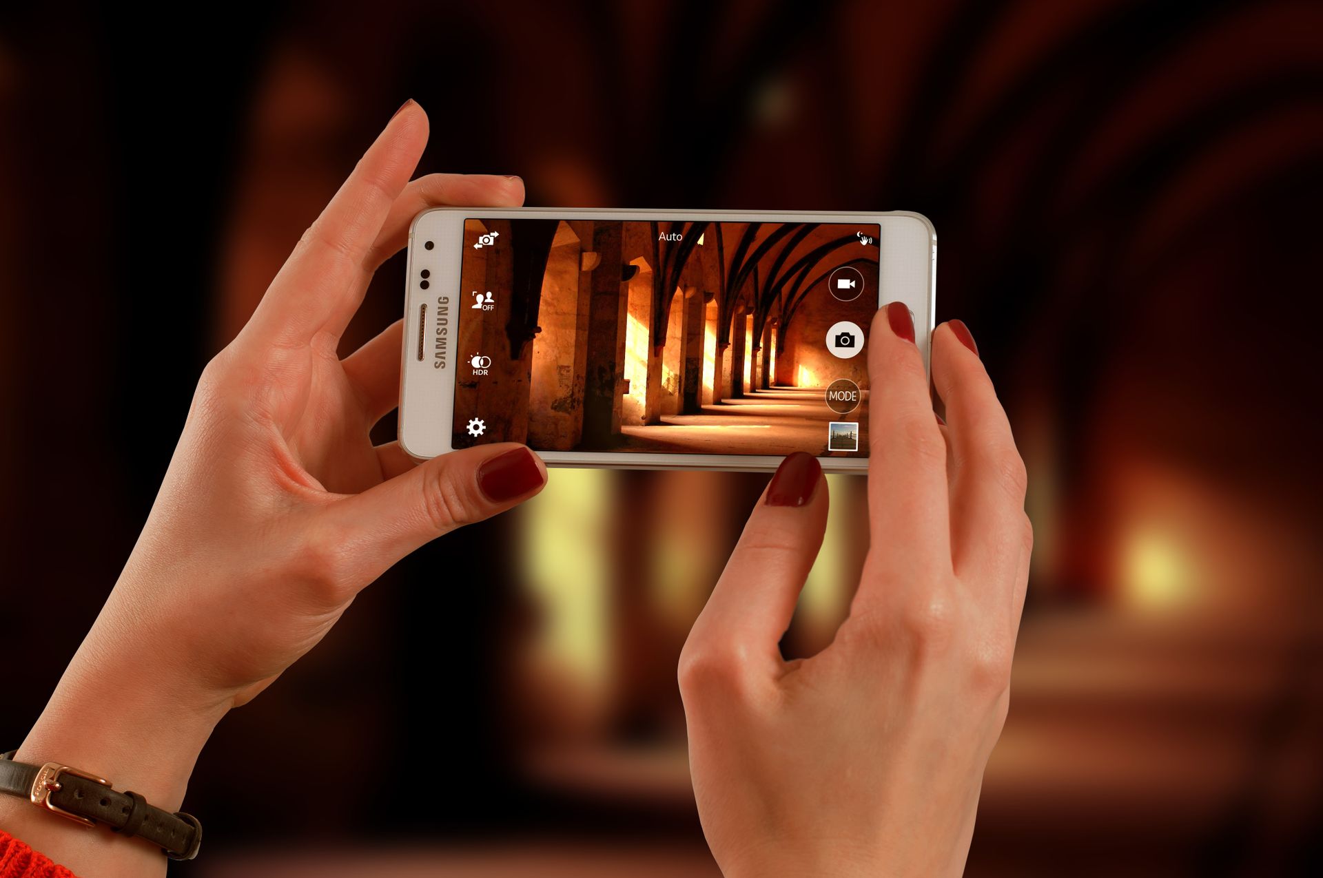 Hands holding a smartphone to photograph stunning architectural arches.