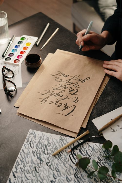 Person Writing with Ink Pen on Craft Paper · Free Stock Photo