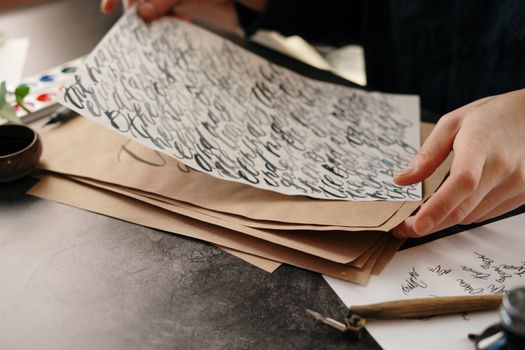 Hands crafting elegant calligraphy on paper, showcasing traditional handwriting art.