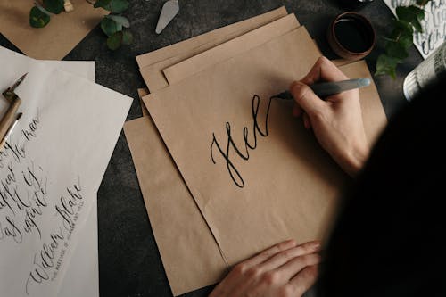 Free Person Writing On Brown Paper  Stock Photo