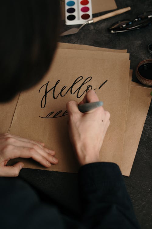 Free Person Writing on Brown Paper Stock Photo