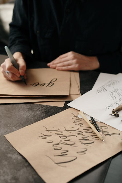Person Writing on Craft Paper with Ink
