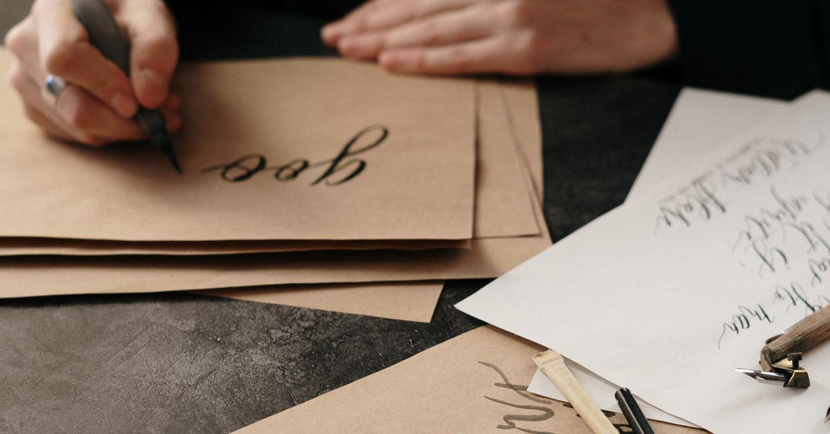 Person Writing on Craft Paper with Ink · Free Stock Photo