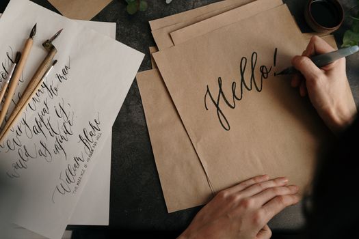 Handwriting with ink on paper in an artistic calligraphy style, "Hello!" message.