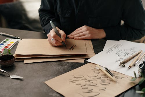 Person Writing with Ink Pen on Paper