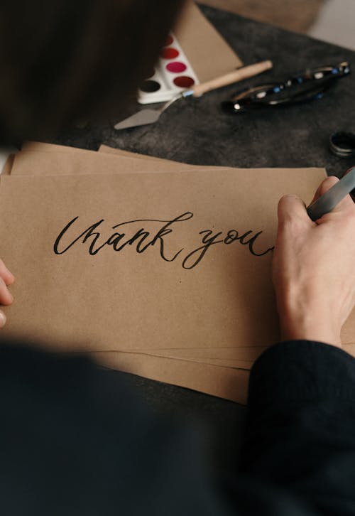 Gratis Persona Che Scrive Su Carta Marrone Per Stampante Foto a disposizione
