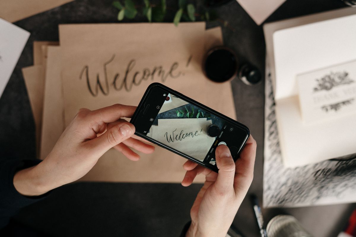 Person holding a smartphone with horoscope app open next to coffee