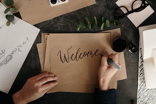 Person Writing On Brown Paper 