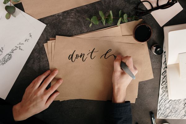 Hand lettering in ink on kraft paper — photo by cottonbro studio on Pexels