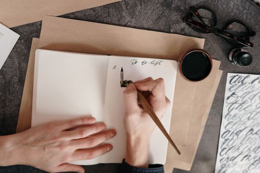 Top view of a to-do list with calligraphy pen on a desk with ink.