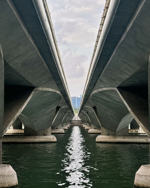 Free Captivating symmetry under a Singaporean bridge reflecting on water. Stock Photo