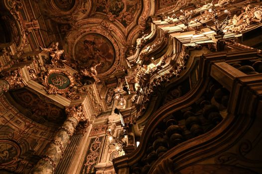 Intricate baroque interior with detailed carvings and golden ornamentation, showcasing architectural elegance.