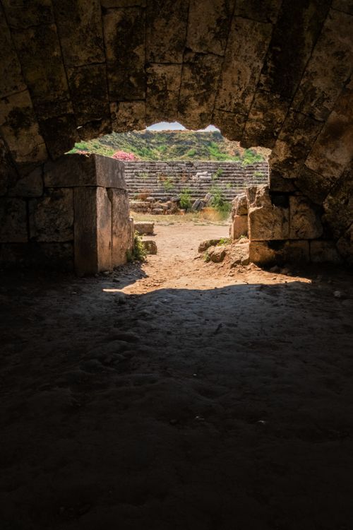 Free View through a stone archway to an ancient amphitheater, capturing historic architecture. Stock Photo
